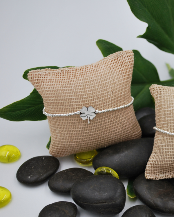 Pulsera elastica de bolitas de plata con trebol
