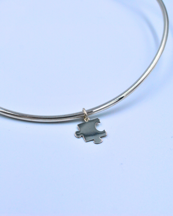 Dije de plata con forma de pieza de rompecabezas