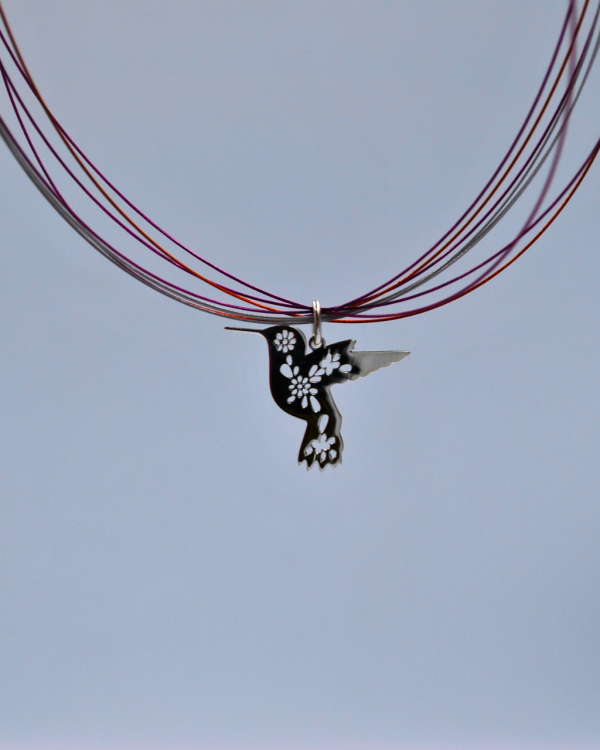 Dije de plata con forma de colibri con flores