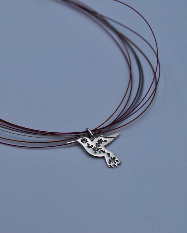Dije de plata con forma de colibri con flores