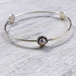 Brazalete de plata con tres perlas decorativas.